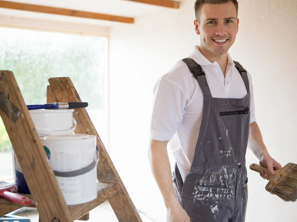 Decorator on ladder applying paint with brush in Bath, Bath Decorators